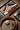 A flat lay of ColsenKeane products (belt, valet tray, nails clippers, flask, and perfume) on a cement floor.