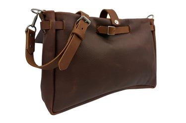 The lid-off view of a dark brown leather shoulder bag with a wide front flap, a coordinating adjustable leather strap, and silver-tone metal hardware, shown on a plain white background.