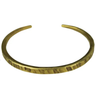 A hammered gold-tone metal cuff bracelet on a plain white background.